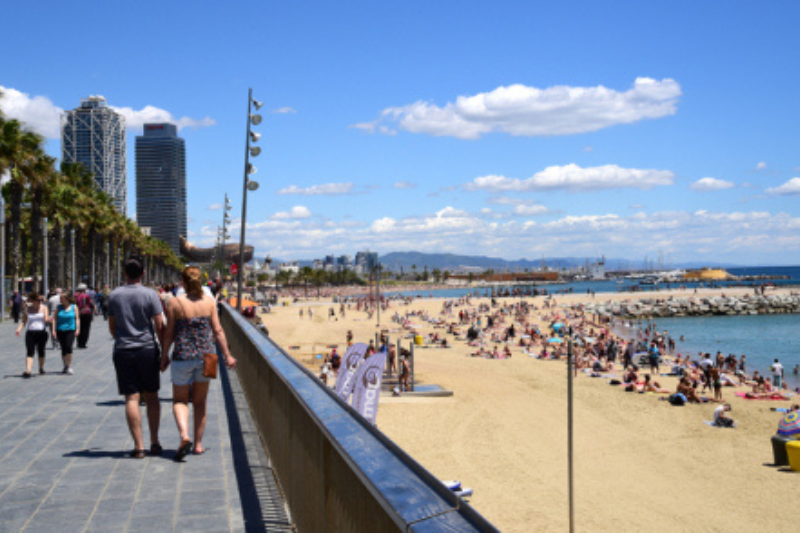 ชายหาด Barceloneta ในบาร์เซโลนา ช่วงหน้าร้อน มีโบสถ์ Sagrada Familia เป็นฉากหลัง