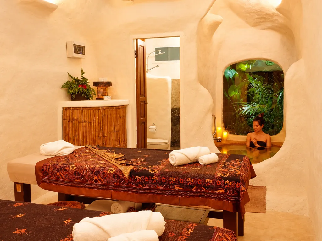 Woman enjoying a relaxing herbal bath in a private cave-inspired spa room at Srimantra Spa Chiang Mai.