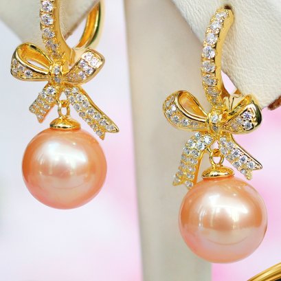ต่างหู Huggie โบว์ประดับเพชร ห้อยไข่มุก Edison สายพันธุ์น้ำจืดคัดเกรด สีพีช ทรงเกือบกลม ขนาด 10.0-10.5 mm เกรด AA+ ตัวเรือนต่างหูแบบ Huggie วัสดุเงินแท้ 925 ชุบสีทอง ประดับเพชร CZ / 9.3.65