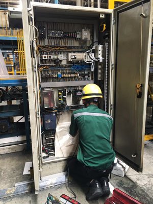 วิศวกรและช่างเทคนิคจากทีมรับเหมางานระบบไฟฟ้าอุตสาหกรรมกำลังติดตั้งตู้ควบคุมไฟฟ้าในโรงงาน พร้อมเครื่องมือวัดและอุปกรณ์ความปลอดภัยครบครัน วิศวกรและช่างเทคนิคจากทีมรับเหมางานระบบไฟฟ้าอุตสาหกรรมกำลังติดตั้งตู้ควบคุมไฟฟ้าในโรงงาน พร้อมเครื่องมือวัดและอุปกรณ์ความปลอดภัยครบครัน