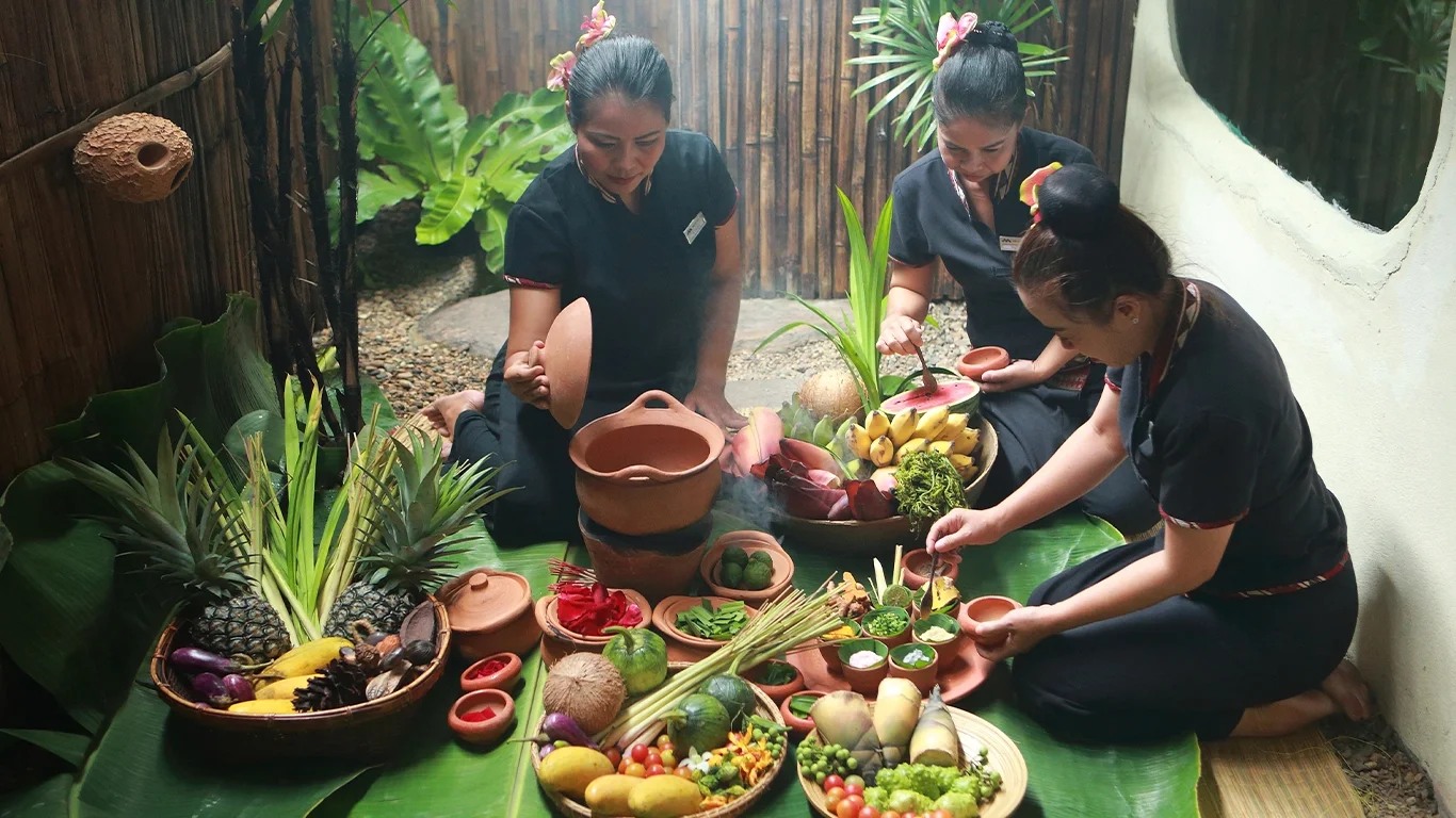 Chiang Mai spa staff preparing various Thai herbs and fruits for natural healing therapies.
