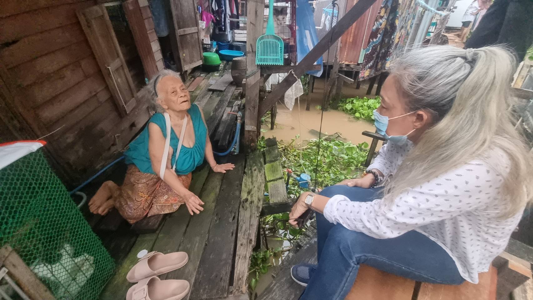 นนทบุรี  คุณยายสุดดีใจติดไฟทางให้กับชุมชนผู้ประสบภัยน้ำท่วม