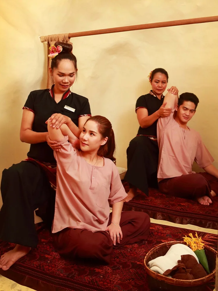 Clients receiving traditional Thai massages from therapists at Srimantra Spa Chiang Mai, focusing on stretching and muscle relaxation.