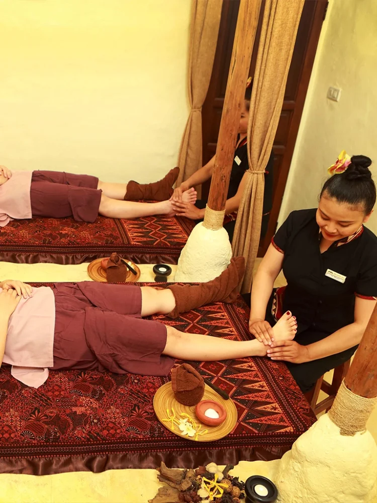 Clients enjoying relaxing foot massages by expert therapists in a treatment room at Srimantra Spa Chiang Mai.