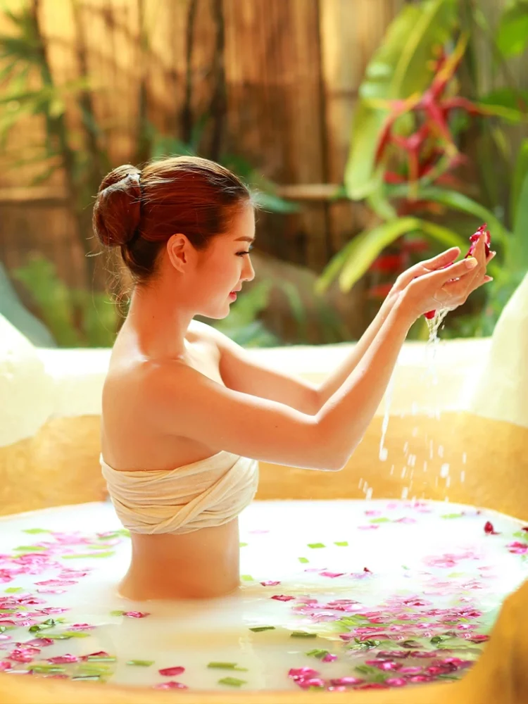 Woman enjoying a beautiful floral milk bath in a private tub at Srimantra Spa Chiang Mai, symbolizing relaxation.