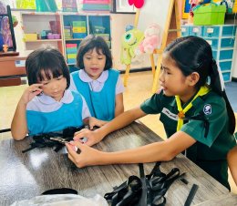  พี่ๆ สอนน้องอนุบาลทำโบสีดำติดเสื้อ ถวายความอาลัยพระพันปีหลวง