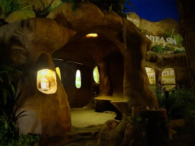 ทางเข้าสปา Srimantra Spa ที่ออกแบบคล้ายถ้ำในเชียงใหม่ ตกแต่งด้วยแสงไฟอบอุ่นและพืชพรรณธรรมชาติ สร้างบรรยากาศลึกลับ