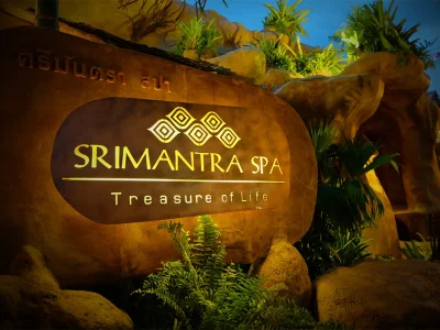 ป้าย Srimantra Spa - Treasure of Life โลโก้ทองส่องสว่างบนหินธรรมชาติ พร้อมต้นไม้เขียวชอุ่มยามค่ำคืนในเชียงใหม่