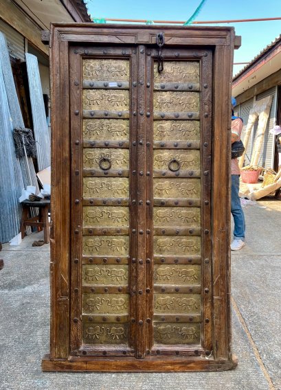 ประตูไม้เก่าบานเล็กประดับแผ่นทองเหลืองตอกลายช้าง