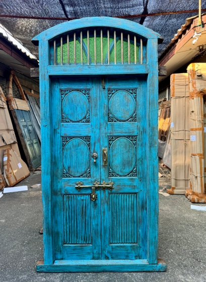 ประตูบานใหญ่ทรงสูงสีฟ้ามีช่องแสงหน้าต่าง