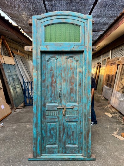 ประตูไม้เก่าสีฟ้าแต่งช่องแสงกระจกลายพิกุล