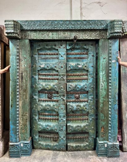ประตูบานใหญ่ไม้หนาสีฟ้าเขียวแกะสลักลาย