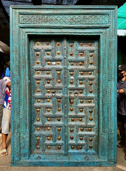 ประตูเข้าบ้านไม้เก่าสีฟ้าแต่งคู่ทองเหลืองเต็มหน้าบาน