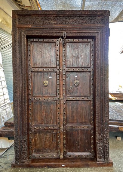 ประตูบ้านไม้เนื้อหนาแผ่นใหญ่แต่งหมุดดอกไม้รอบบาน