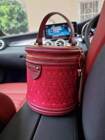 กระเป๋าผลิตจากผ้าไหมยกดอกลำพูนสีแดงเลือดหมู