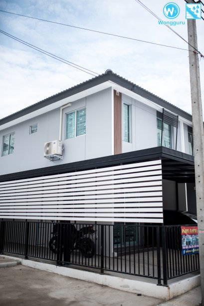 หลังคาเมทัลชีทซ่อนรางน้ำฝนสแตนเลส พร้อมระแนงไม้บังตา กับงานหลังคากันสาดสไตล์โมเดิร์น