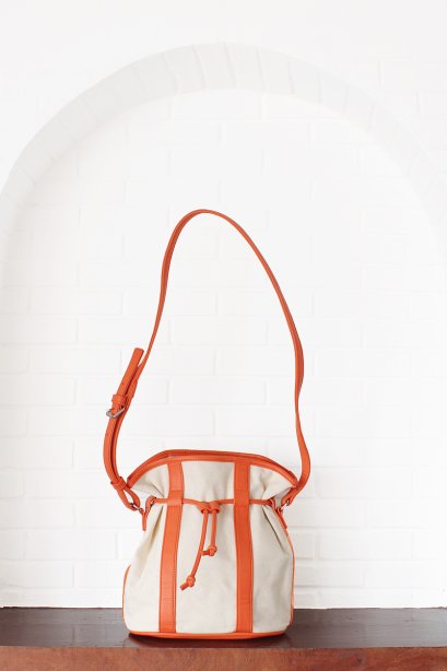 สตรีทแฟชั่น กระเป๋าสะพาย ทรงขนมจีบ ตัดต่อหนัง และ ผ้าแคนวาส สีขาว-ส้ม